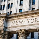 Close-Up Image of a Building With Columns And The Words “NEW YORK” Engraved Across The Façade